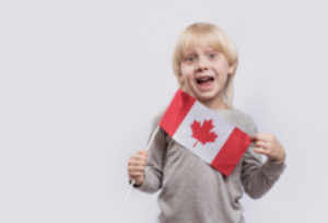 a kid holding a Canadian flag while making a fun facial expression